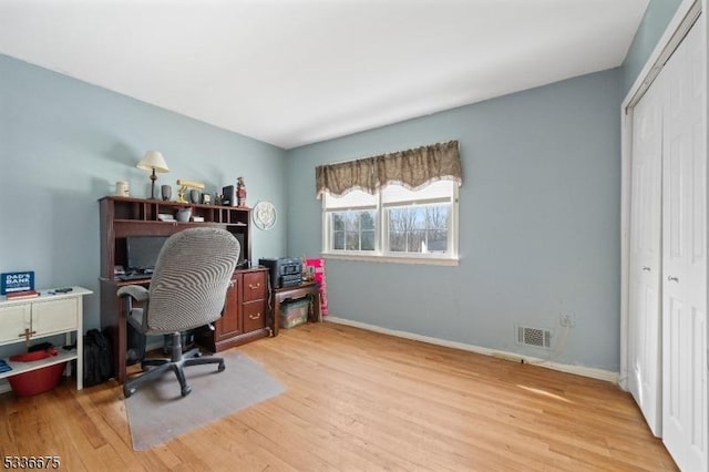 office space with light wood-type flooring, baseboards, and visible vents