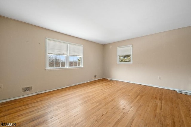 empty room featuring visible vents and light wood finished floors