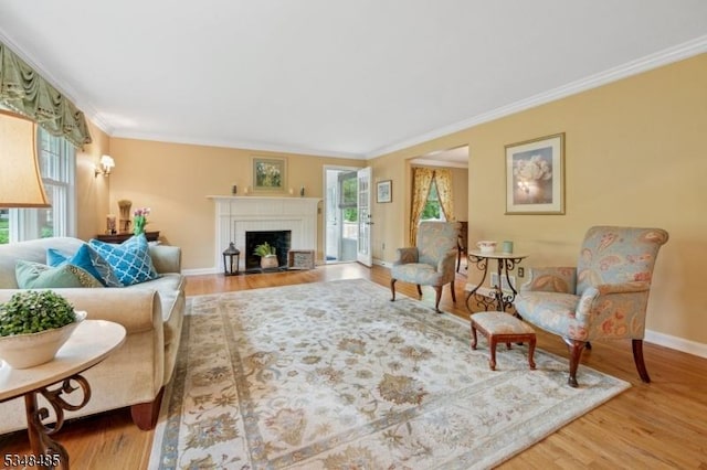 living room with plenty of natural light, ornamental molding, and wood finished floors