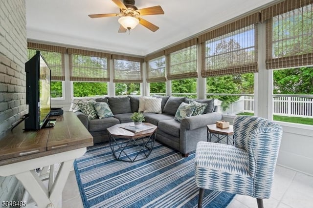 sunroom with healthy amount of natural light, a ceiling fan, and an outdoor hangout area