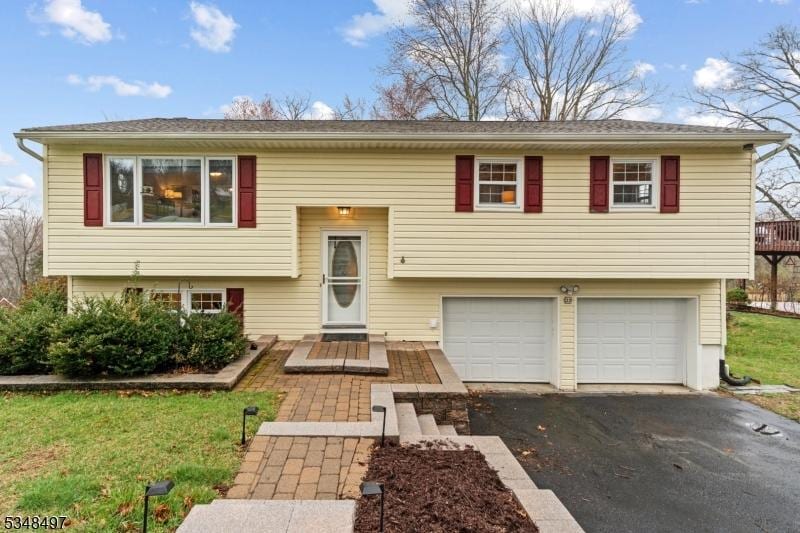 bi-level home with a garage and aphalt driveway