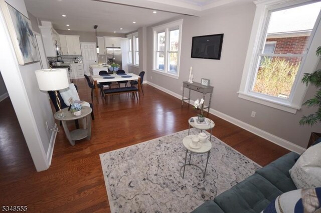 living room with dark wood-style flooring, baseboards, and recessed lighting