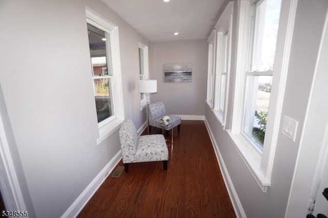 hallway featuring wood finished floors, baseboards, visible vents, and recessed lighting