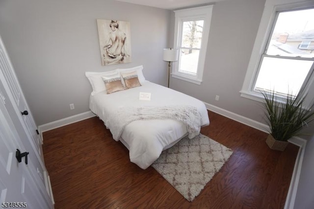 bedroom with dark wood-style flooring and baseboards