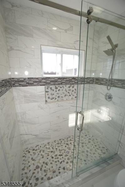 bathroom with toilet and a stall shower