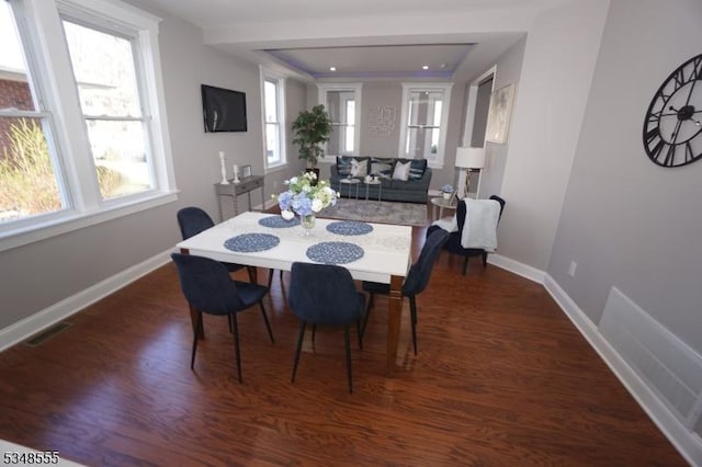 dining space with visible vents, baseboards, and wood finished floors
