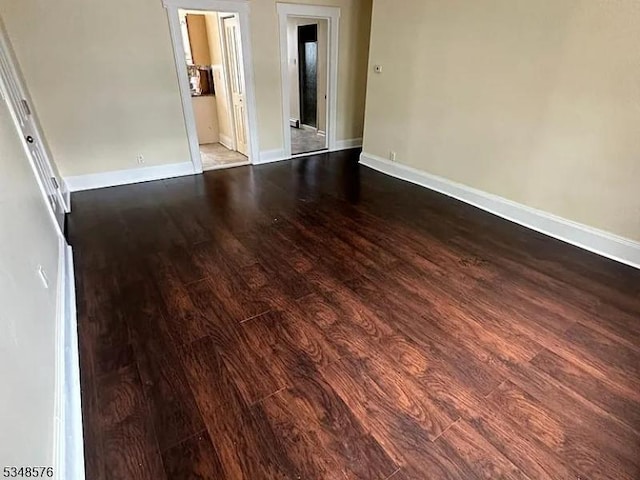 spare room with wood finished floors and baseboards