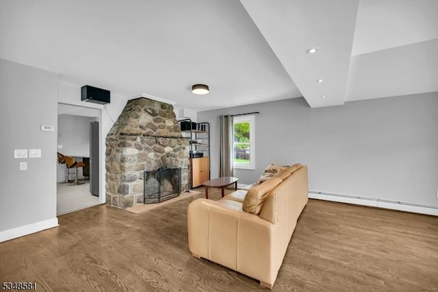 677 Warwick Tpke, West Milford Twp, NJ 07421 - living area featuring wood finished floors, a stone fireplace, a baseboard radiator, recessed lighting, and baseboards