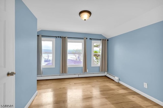 677 Warwick Tpke, West Milford Twp, NJ 07421 - spare room featuring vaulted ceiling, a baseboard heating unit, baseboards, and wood finished floors