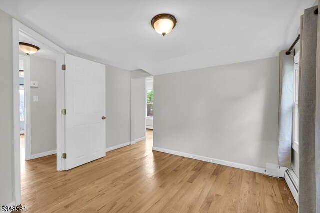 677 Warwick Tpke, West Milford Twp, NJ 07421 - empty room with light wood finished floors, baseboards, and baseboard heating
