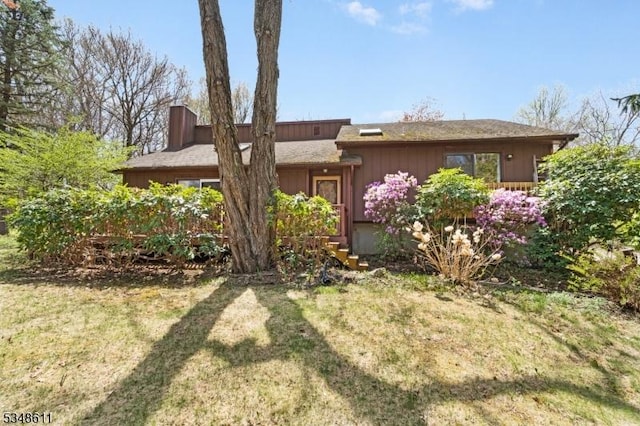 view of front of home with a chimney and a front lawn