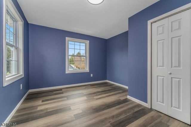 63 S Lincoln Ave, Washington Boro, NJ 07882 - unfurnished bedroom featuring a closet, baseboards, multiple windows, and wood finished floors