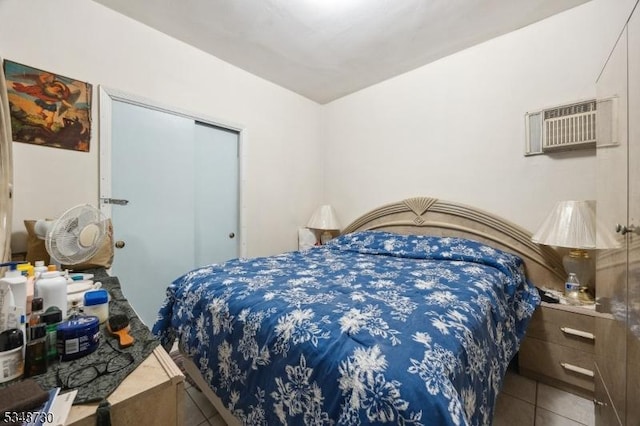 tiled bedroom featuring a closet and an AC wall unit