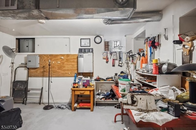 garage with electric panel, visible vents, and a workshop area