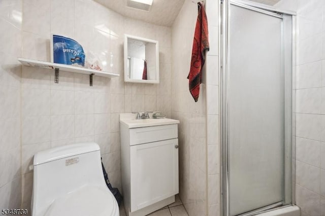 full bathroom with toilet, tile walls, a stall shower, and vanity