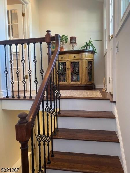 stairs with wood finished floors and baseboards