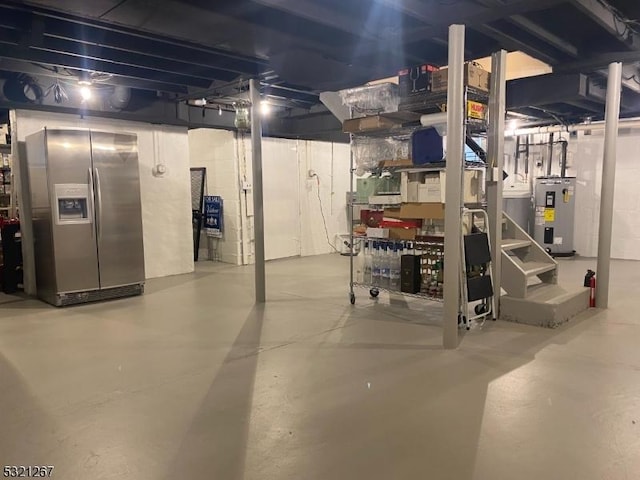 unfinished below grade area featuring water heater and stainless steel fridge