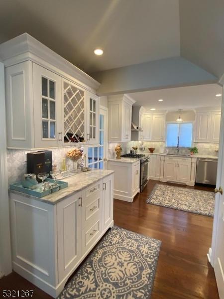 kitchen with white cabinetry, tasteful backsplash, appliances with stainless steel finishes, and dark wood finished floors