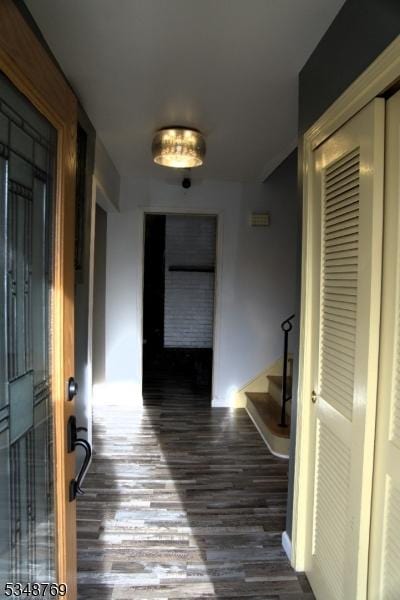 hall with wood finished floors, baseboards, and stairway