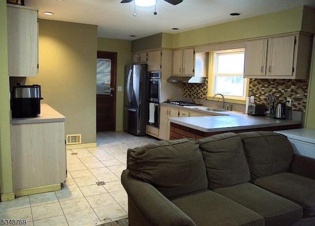 kitchen featuring tasteful backsplash, visible vents, a ceiling fan, a peninsula, and stainless steel appliances