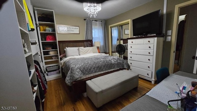bedroom featuring a chandelier and wood finished floors