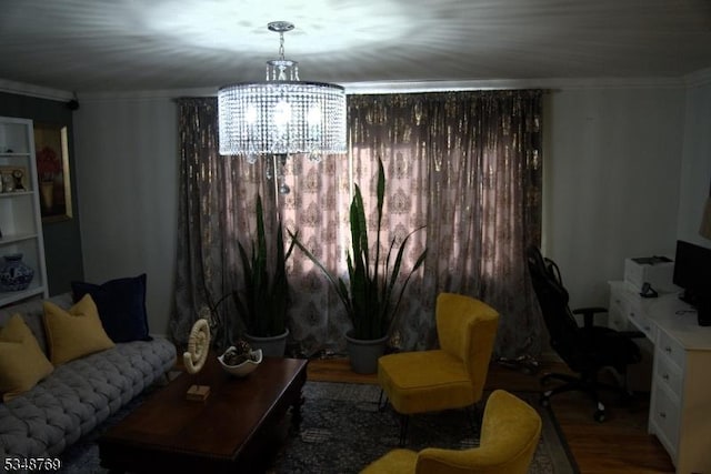 living area featuring crown molding, wood finished floors, and an inviting chandelier