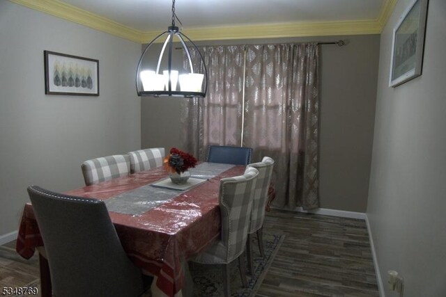 dining area with ornamental molding, baseboards, a notable chandelier, and wood finished floors
