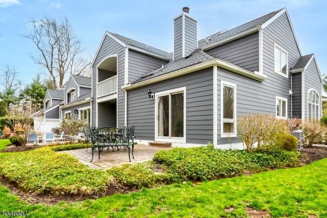 rear view of property with a chimney and a patio