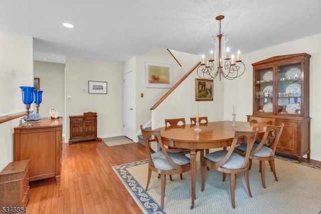 dining space with stairs, light wood-type flooring, baseboards, a notable chandelier, and recessed lighting