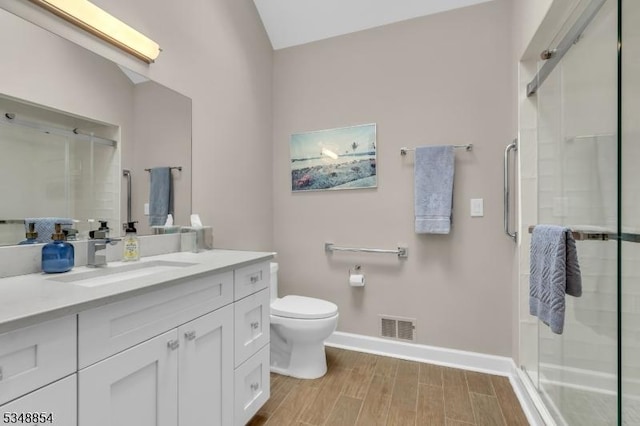 bathroom with baseboards, vanity, visible vents, and a shower stall