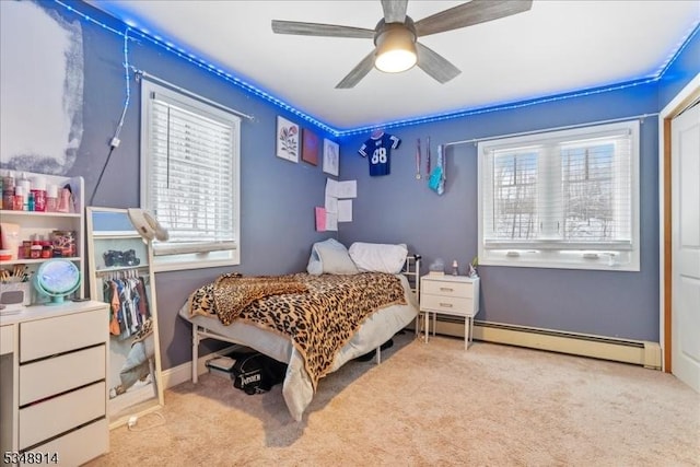 carpeted bedroom featuring baseboards, a ceiling fan, and a baseboard heating unit