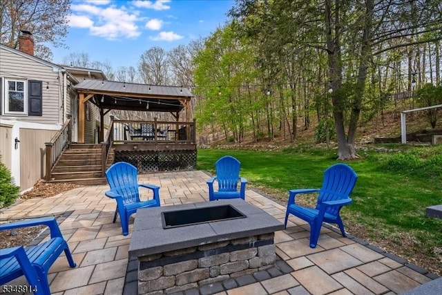 view of patio with stairs, a fire pit, and a deck