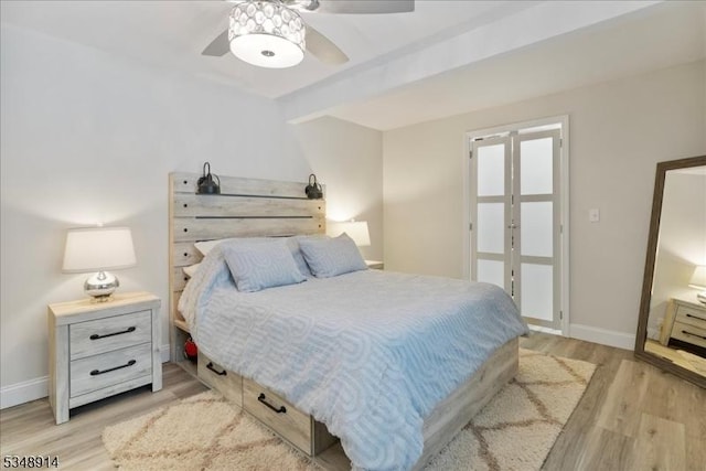 bedroom with a ceiling fan, baseboards, and light wood-style floors