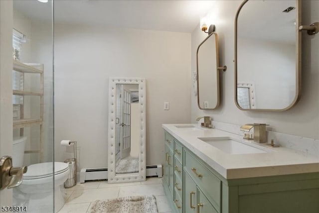 bathroom with double vanity, baseboard heating, a sink, tile patterned floors, and toilet