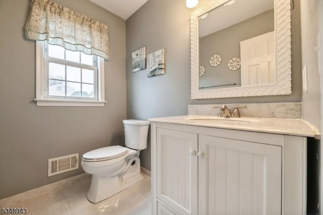 half bath featuring visible vents, tile patterned flooring, baseboards, vanity, and toilet
