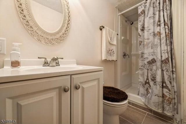 bathroom featuring vanity, tile patterned floors, a stall shower, and toilet