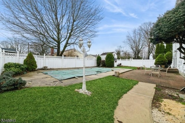 view of yard with shuffleboard, a fenced backyard, and a patio area