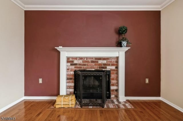 room details with baseboards, ornamental molding, a brick fireplace, and wood finished floors