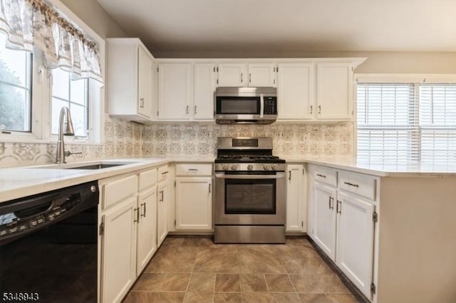 kitchen featuring light countertops, white cabinets, appliances with stainless steel finishes, and a sink
