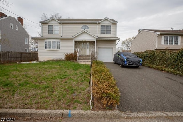 view of front of property featuring a garage, a front yard, fence, and aphalt driveway