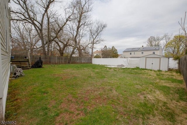view of yard featuring an outbuilding, a storage unit, and a fenced backyard