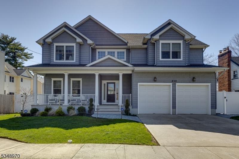 craftsman-style home featuring an attached garage, covered porch, fence, concrete driveway, and a front lawn
