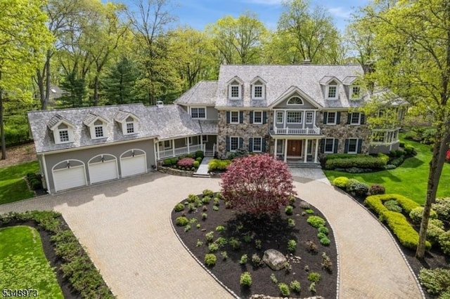 2 Queens Ct, Mendham Twp, NJ 07960 - view of front of house featuring decorative driveway, a garage, a balcony, and view of scattered trees