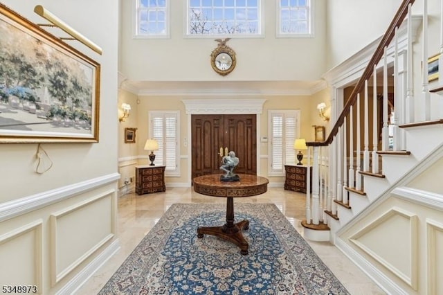 2 Queens Ct, Mendham Twp, NJ 07960 - entrance foyer with a high ceiling, stairway, ornamental molding, wainscoting, and a decorative wall