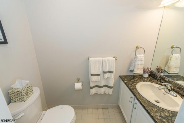 half bath featuring toilet, vanity, baseboards, and tile patterned flooring