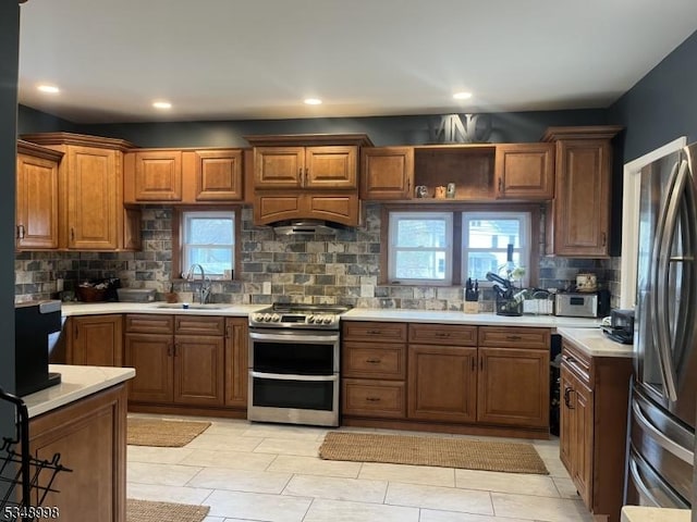 4 Municipal Dr, Pohatcong Twp, NJ 08865 - kitchen featuring brown cabinetry, appliances with stainless steel finishes, light countertops, a sink, and backsplash