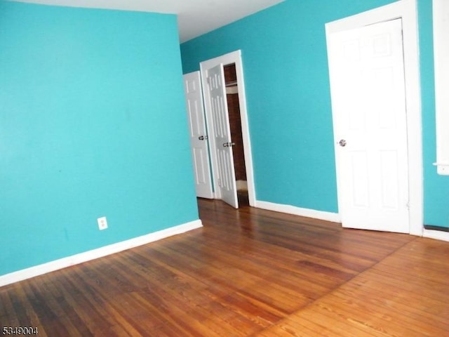 unfurnished bedroom featuring baseboards and wood finished floors