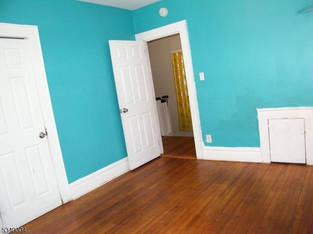 empty room with baseboards and wood finished floors