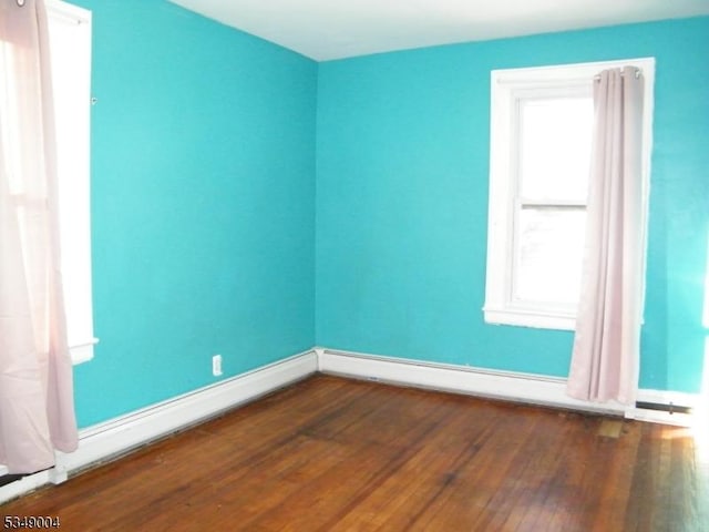 empty room with baseboards and wood finished floors