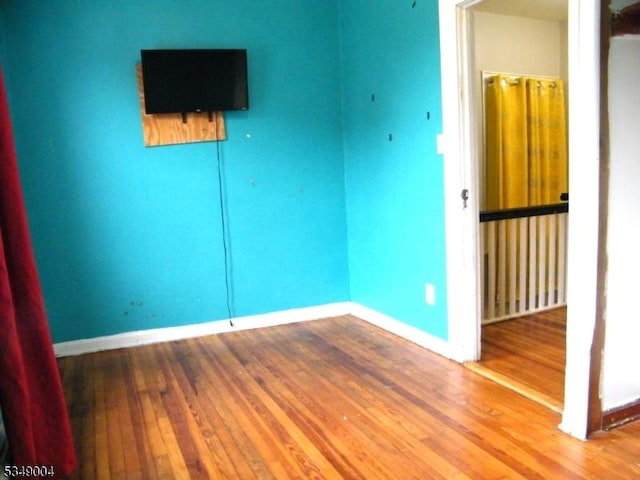 empty room with baseboards and wood finished floors
